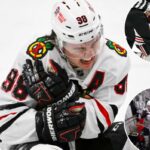 O pivô do Chicago Blackhawks, Connor Bedard (98), reage com dor após um confronto com o pivô do St. Louis Blues, Brayden Schenn, durante o terceiro período.