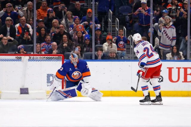 O goleiro do New York Islanders, David Rittich, desvia o disco do jogador do New York Rangers, Carson Soucy.