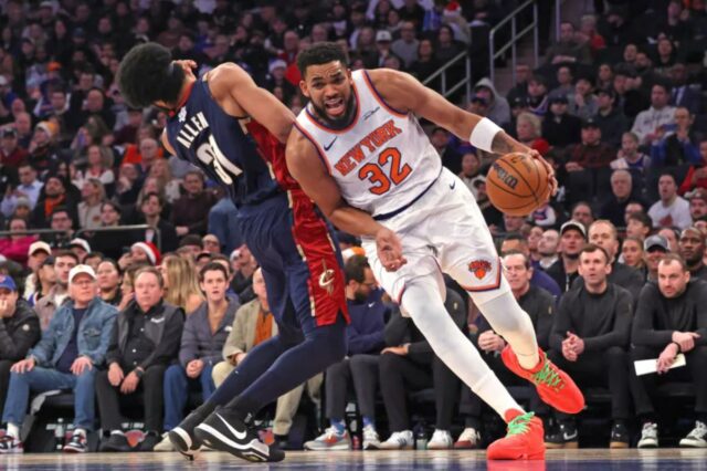   O pivô Karl-Anthony Towns #32 do New York Knicks é punido por uma falta ofensiva ao acertar o pivô Jarrett Allen #31 do Cleveland Cavaliers durante o primeiro quarto.