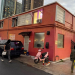 Prédio em Honolulu, com carros estacionados do lado de fora e uma scooter rosa. Imagem compartilhada pela polícia, com o distintivo do Departamento de Polícia de Honolulu no canto. A polícia de Honolulu encerrou operação ilegal de jogos de azar, apreendendo dinheiro e máquinas