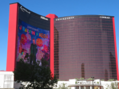 Ação judicial foi movida contra Resorts World por jogador de apostas altas Edifício Las Vegas Resorts World, com céu azul atrás dele.