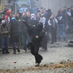 Um manifestante atira um objeto, enquanto agricultores protestam contra o acordo de livre comércio UE-Mercosul entre a União Europeia e os países sul-americanos do Mercosul, no dia de uma cimeira de líderes da União Europeia, em Bruxelas, Bélgica, 18 de dezembro de 2025. REUTERS/Yves Herman