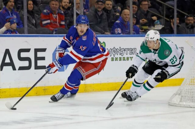 Alexis Lafrenière, do New York Rangers, com o disco, seguido por Esa Lindell, do Dallas Stars.