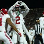 O lateral defensivo do Alabama, Zabien Brown (2), forma um coração com as mãos enquanto comemora seu touchdown com o companheiro de equipe nº 41 durante um jogo de futebol.