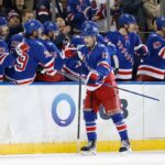 O ala esquerdo do New York Rangers, Alexis Lafrenière (13), é saudado por seus companheiros no banco após marcar um gol no segundo período.