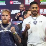 Jake Paul, à esquerda, e Anthony Joshua se enfrentam durante uma coletiva de imprensa promovendo sua próxima luta de boxe de pesos pesados, quarta-feira, 17 de dezembro de 2025, em Miami Beach, Flórida.