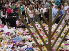 Após o ataque de Bondi, o nível de terror da Austrália permanece em “provável”. O que isso significa? Uma menorá de Hanukkah representa um tributo floral enquanto as pessoas se reúnem para prestar suas homenagens perto do Pavilhão Bondi em Bondi Beach hoje.