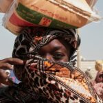 Uma mulher sudanesa deslocada de El Fasher recolhe ajuda alimentar no campo de refugiados de El Afadh.