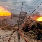 Uma pessoa passa por um outdoor que mostra um soldado russo participando de uma ação militar na Ucrânia lendo "O orgulho da Rússia" em São Petersburgo, 24 de novembro de 2025