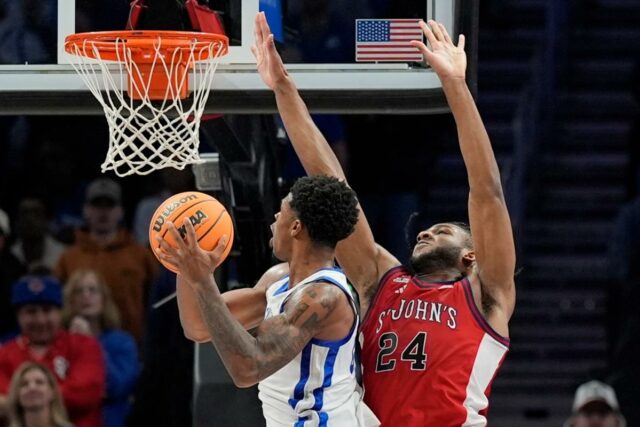   Otega Oweh tenta dar um chute enquanto Zuby Ejiofor defende durante a derrota do St. John por 78-66 para o Kentucky em 20 de dezembro de 2025 em Atlanta.