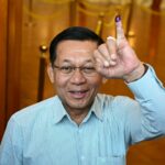 As pessoas fazem fila para votar dentro de uma seção eleitoral durante a primeira fase das eleições gerais de Mianmar em Yangon, em 28 de dezembro de 2025. A votação foi aberta nas eleições fortemente restritas dirigidas pela junta de Mianmar, iniciando uma votação de um mês que os vigilantes da democracia descrevem como uma reformulação do regime militar.