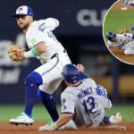 Bo Bichette, do Toronto Blue Jays, força Max Muncy, do Los Angeles Dodgers, a sair durante a sexta entrada da World Series de 2025.