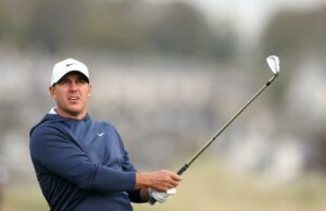 Brooks Koepka deixando o LIV Golf em uma surpresa de separação ‘mutuamente acordada’ Jogador de golfe com boné branco e top azul marinho segurando um taco de golfe no Alfred Dunhill Links Championship 2025 - primeiro dia.