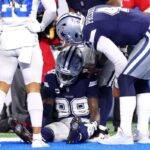 Dak Prescott #4 verifica CeeDee Lamb #88 do Dallas Cowboys depois que ele deixou cair uma bola na end zone e deixou o jogo contra o Detroit Lions durante o terceiro quarto no Ford Field em 04 de dezembro de 2025 em Detroit, Michigan.