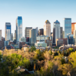 Horizonte de Calgary, com folhagens em primeiro plano e edifícios semelhantes a arranha-céus ao fundo. Cinco presos em Calgary por suposta fraude em cassino após investigação da equipe