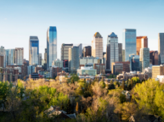 Cinco presos em Calgary por suposta fraude em cassino após investigação da equipe Horizonte de Calgary, com folhagens em primeiro plano e edifícios semelhantes a arranha-céus ao fundo. Cinco presos em Calgary por suposta fraude em cassino após investigação da equipe