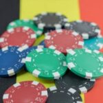 Uma bandeira belga coberta de fichas de pôquer. Comissão Belga de Jogos assina acordo com DNS Bélgica sobre detecção de jogos ilegais