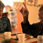A partir da esquerda, Mike Morse, Maria Crane e Edy Mack reagem a um presente de elefante branco durante uma festa de Natal, domingo, 14 de dezembro de 2025. Todos eram investidores da LeFever Mattson. (Kent Porter / Imprensa Democrata)