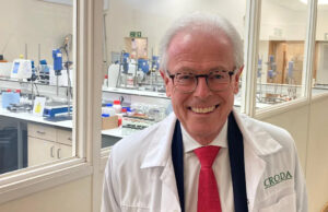 Como uma empresa centenária passou de Hull para Hollywood Um casal de meia-idade está em frente a um conjunto de portas brancas segurando uma claquete de filme e um recorte de revista. À esquerda, um homem com cabelos escuros e grisalhos, vestindo um blazer fulvo e com o polegar para cima. À direita uma mulher de cabelos castanhos, amarrados para trás, vestindo um suéter azul e rosa. A claquete é branca com as palavras "Óleo de Lorenzo, diretor George Miller, câmera John Seale" impresso nele em letras vermelhas. O recorte da revista inclui a foto de um menino vestindo uma camisa de rugby listrada de vermelho e branco.