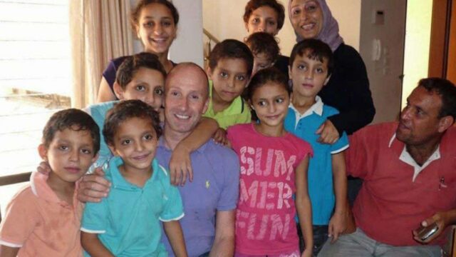 Jovem de boné e vestido em um campo de futebol