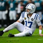 O quarterback do Colts, Daniel Jones, agarra o tornozelo direito após sofrer uma lesão contra o Jaguars em 7 de dezembro de 2025.