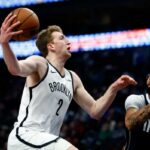 Danny Wolf nº 2 do Brooklyn Nets vai para a cesta enquanto Anthony Davis nº 3 do Dallas Mavericks defende no primeiro tempo no American Airlines Center em 12 de dezembro de 2025 em Dallas, Texas.