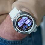 O Samsung Galaxy Watch 8 Classic em um pulso em frente a uma parede de concreto
