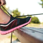 Mão segurando um smartphone exibindo um widget ‘Foco’ com uma lista de metas diárias na tela inicial.