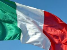 Detenções efetuadas em alegada operação ilegal de jogo com volume de negócios de 25 milhões de euros Uma fotografia em close da bandeira italiana ondulando dramaticamente sob uma forte brisa contra um céu azul claro. O tecido tricolor apresenta listras verticais em verde esmeralda vívido, branco imaculado e vermelho carmesim profundo, ondulando com movimento dinâmico, criando ondas e dobras naturais que captam a luz. A textura da bandeira é bem visível, mostrando a trama do tecido à medida que se estica e se contrai com o vento. A forte luz do sol mediterrâneo ilumina as cores por trás, fazendo-as parecer luminosas e saturadas, ao mesmo tempo que lança sombras sutis nos vincos do tecido.