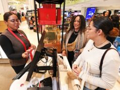 Devolvendo um presente de feriado? As grandes lojas de varejo agora cobrarão por isso – até US$ 45 Funcionária da Macy's ajudando duas mulheres nas compras de Natal de última hora em uma loja de perfumes.