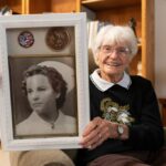 A ex-enfermeira da Marinha da Segunda Guerra Mundial Alice Darrow, 106, de Danville, é recebida pelo primeiro oficial de seu voo de Honolulu, Peter Vanpelt, no Aeroporto Internacional de Oakland na sexta-feira, 5 de dezembro de 2025. Um total de 2.403 americanos foram mortos, e seu marido Dean Darrow foi ferido, mas sobreviveu depois que uma bala foi removida de seu coração. (Cortesia de Chris Smith)