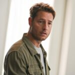 A man stands in front of a window