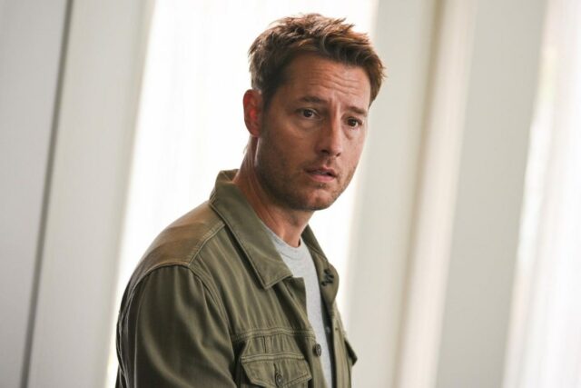 A man stands in front of a window