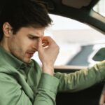 Jeep Wranglers azuis, vermelhos, verdes e pretos dirigindo em uma estrada urbana