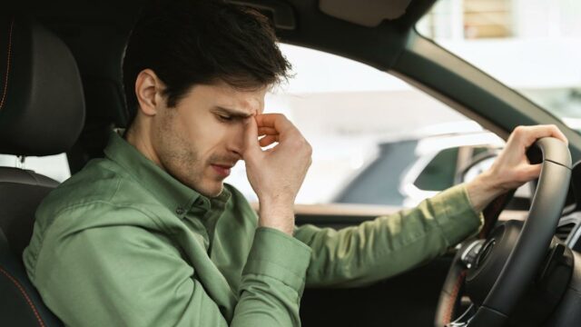 Esta é considerada a marca de carro mais decepcionante em Jeep Wranglers azuis, vermelhos, verdes e pretos dirigindo em uma estrada urbana