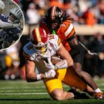 Alexander McPherson, número 98 do Colorado, enfrentando Qua Moss, número 6 do Kansas State, em um jogo de futebol.