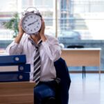 Um empresário de terno entregando um cheque a outra pessoa.