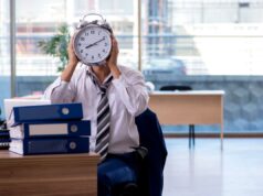 Estado de Nova York aumentará limite de horas extras a partir de 1º de janeiro Um empresário de terno entregando um cheque a outra pessoa.