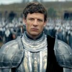 A man in armor stands before an army