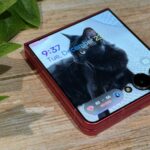 Uma pessoa segura um Samsung Galaxy S25 enquanto destaca o gesto de ativação do botão lateral, com um prompt brilhante ‘Pergunte ao Google Gemini’ aparecendo ao lado do telefone.