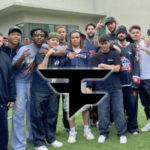 FaZe Clan enfrenta um futuro incerto com a saída dos criadores após negociações fracassadas. Um grupo de jovens posando juntos ao ar livre em frente a um prédio moderno, vestindo roupas casuais, com um grande logotipo do FaZe Clan sobreposto no centro da imagem.