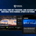 FanDuel e FanDuel Sports Network lançam rastreamento de apostas em jogos da NBA e NHL. Gráfico promocional da FanDuel Sports Network anunciando “Probabilidades ao vivo, rastreamento de apostas em tempo real e vinculação de contas agora integrados à FanDuel Sports Network”. A imagem mostra um jogo de basquete ao vivo em uma tela de TV com probabilidades de apostas e sobreposições de status de apostas, ao lado de um smartphone exibindo o aplicativo FanDuel e uma mensagem sobre como vincular uma conta FanDuel Sports Network ao FanDuel Sportsbook. Os logotipos FanDuel aparecem em um fundo azul.