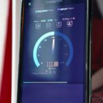 Uma pessoa segurando um smartphone sem sinal em um estádio lotado