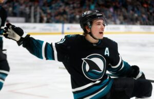 Kurtenbach: É impossível exagerar o suficiente com a estrela dos Sharks, Macklin Celebrini. Mas vou continuar tentando George Kittle (85), do San Francisco 49ers, tira uma foto do mascote do San Jose Sharks, SJ Sharkie, junto com seus companheiros de equipe do 49ers durante o jogo dos Sharks contra o Calgary Flames no segundo período no SAP Center em San Jose, Califórnia, na terça-feira, 16 de dezembro de 2025. (Nhat V. Meyer/Bay Area News Group)