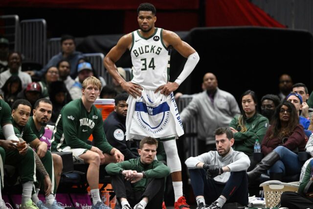 Giannis Antetokounmpo se reúne com companheiros de equipe do Bucks Giannis Antetokounmpo em uniforme branco com