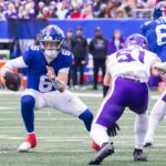 O quarterback Jaxson Dart nº 6 do New York Giants é forçado a sair do bolso pelo linebacker Blake Cashman nº 51 do Minnesota Vikings durante o primeiro tempo no MetLife Stadium, domingo, 21 de dezembro de 2025, em East Rutherford, Nova Jersey.