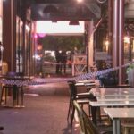 Grupo em fuga após dois homens serem atacados com facões do lado de fora do restaurante