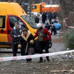 Uma idosa ferida olha pela janela quebrada enquanto um prédio de apartamentos foi atingido por um drone russo durante um ataque aéreo em Kiev, Ucrânia, terça-feira, 23 de dezembro de 2025. (AP Photo/Efrem Lukatsky)