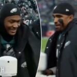 Jalen Hurts sorrindo durante um jogo de futebol.