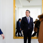 O presidente Donald Trump acena enquanto ele e a primeira-dama Melania Trump chegam no Força Aérea Um, domingo, 30 de novembro de 2025, na Base Conjunta de Andrews, Maryland (AP Photo/Alex Brandon)